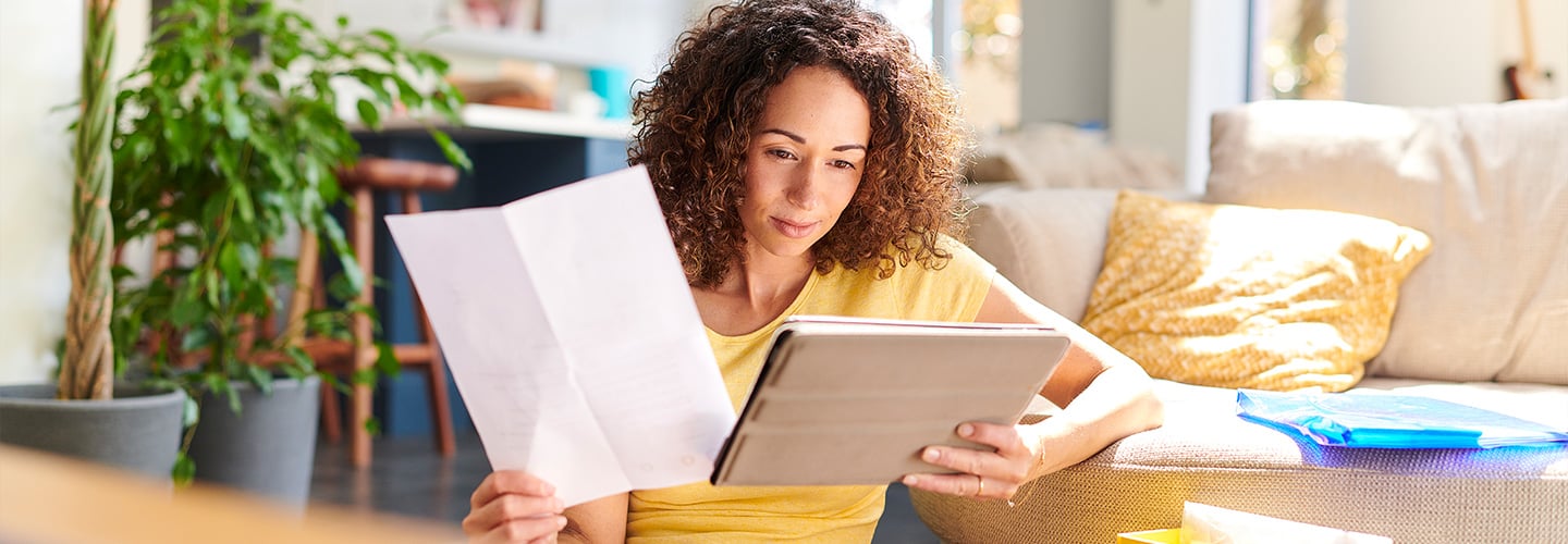 Person sitting in a living room looking at a tablet