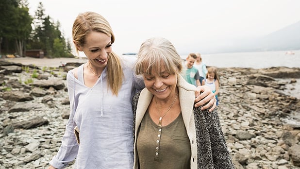 Two women walking near a shoreline