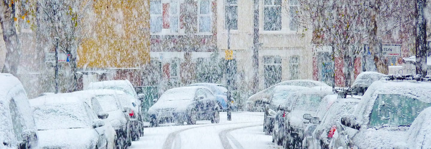 Road with cars covered in snow