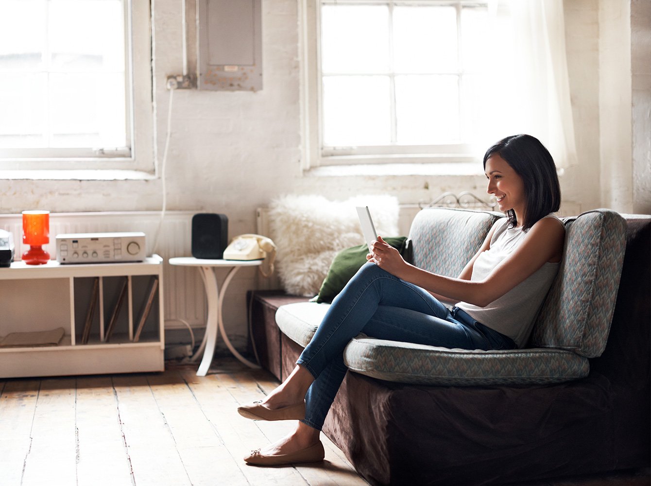 Person sitting on a couch looking at a tablet