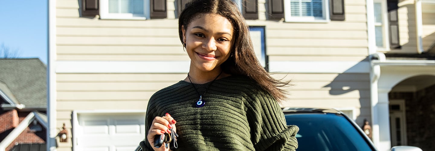 woman smiling and holding keys to a car