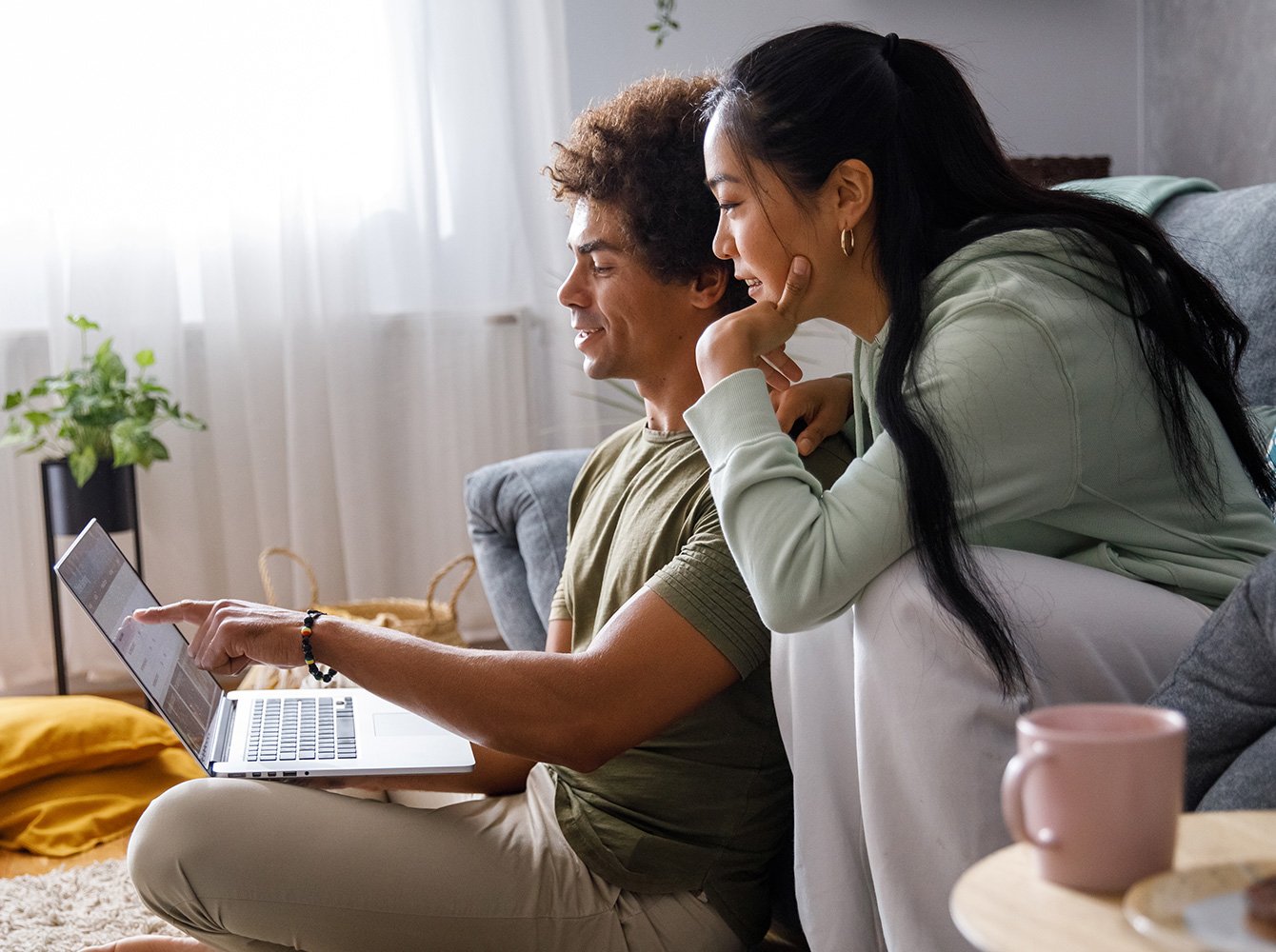 a couple sitting together and looking at a laptop