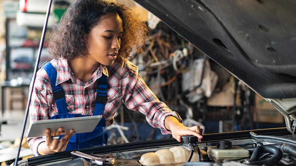 Engineer looking under the hood of a car.