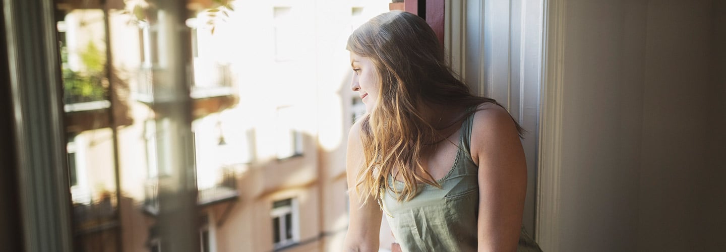 woman looking out the window in an apartment