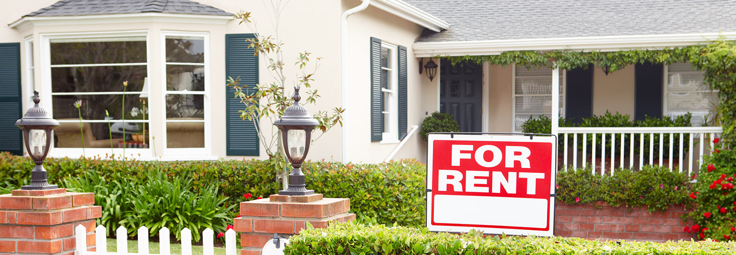 A house with a for sale sign in the front yard.
