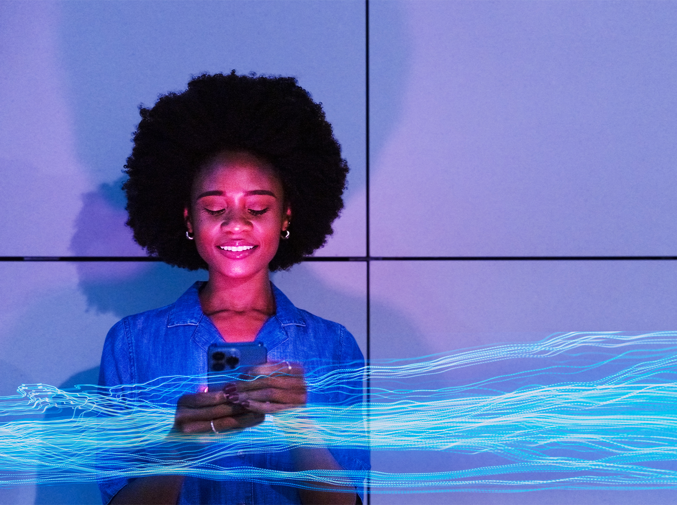 A woman is holding a phone and smiling.