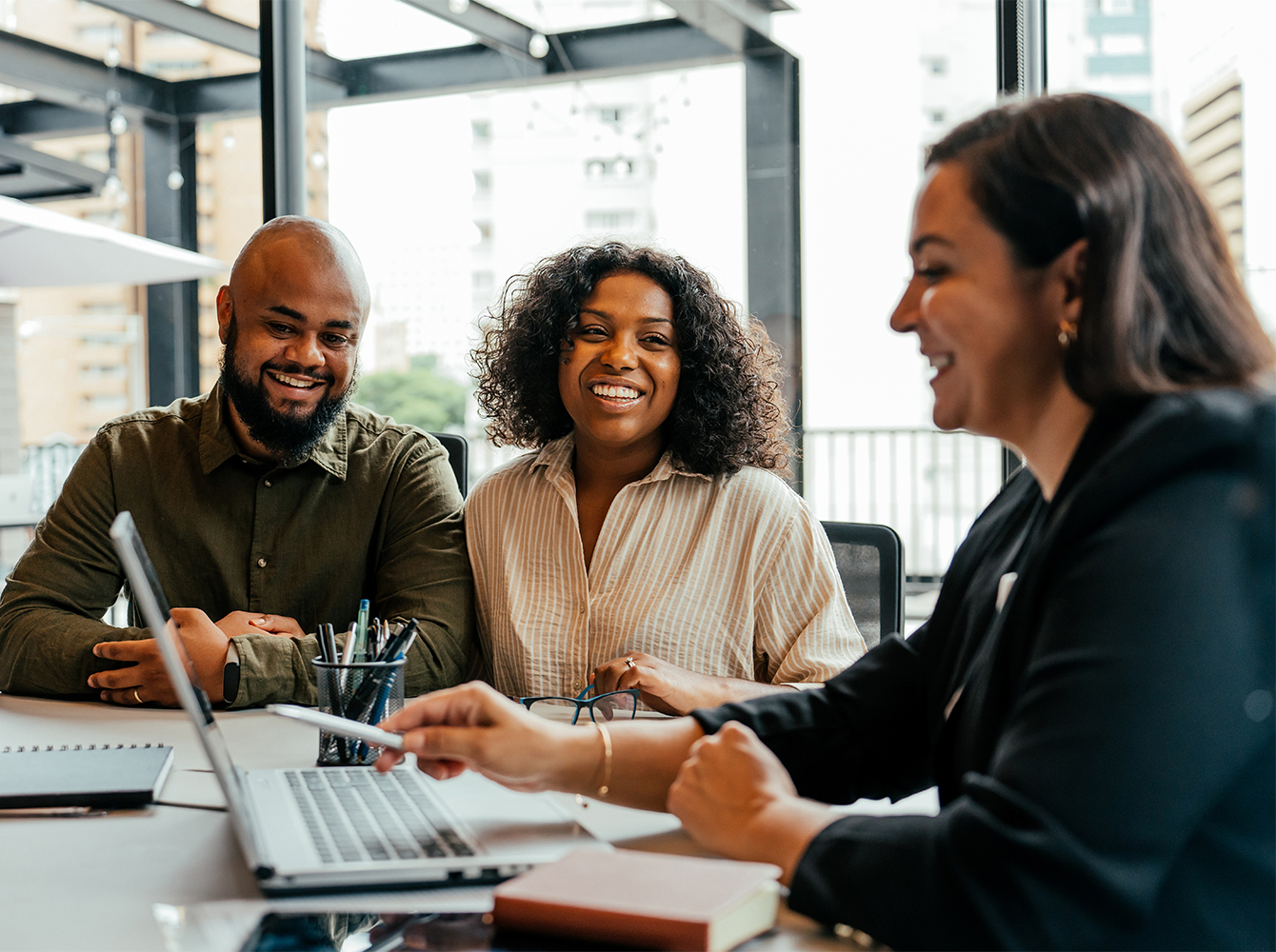A couple is sitting with a realtor looking over paperwork.