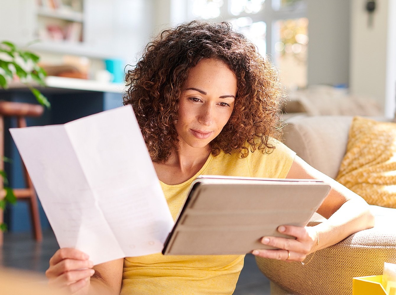 Person sitting in a living room looking at a tablet