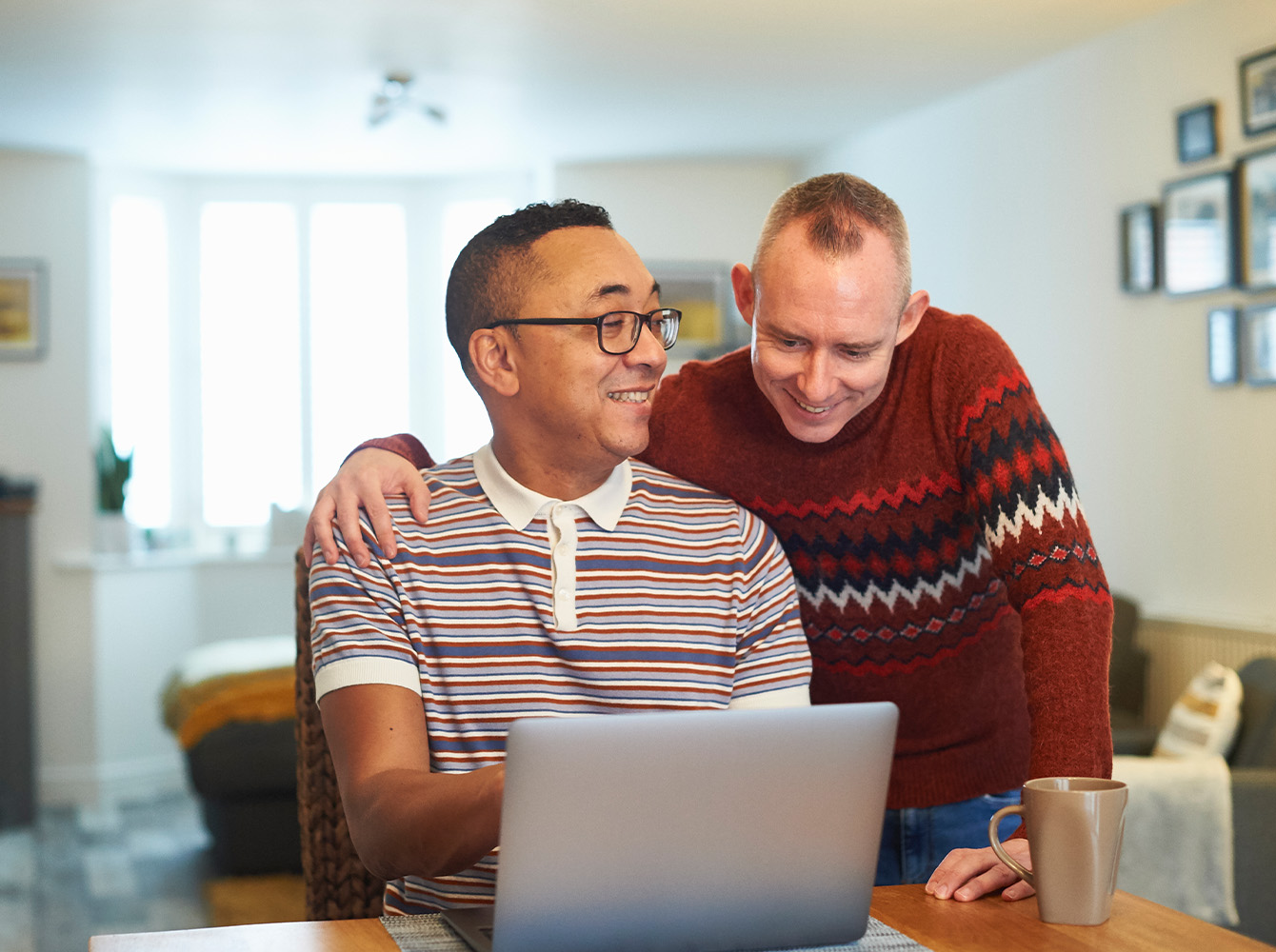 A smiling couple is looking at a laptop together.