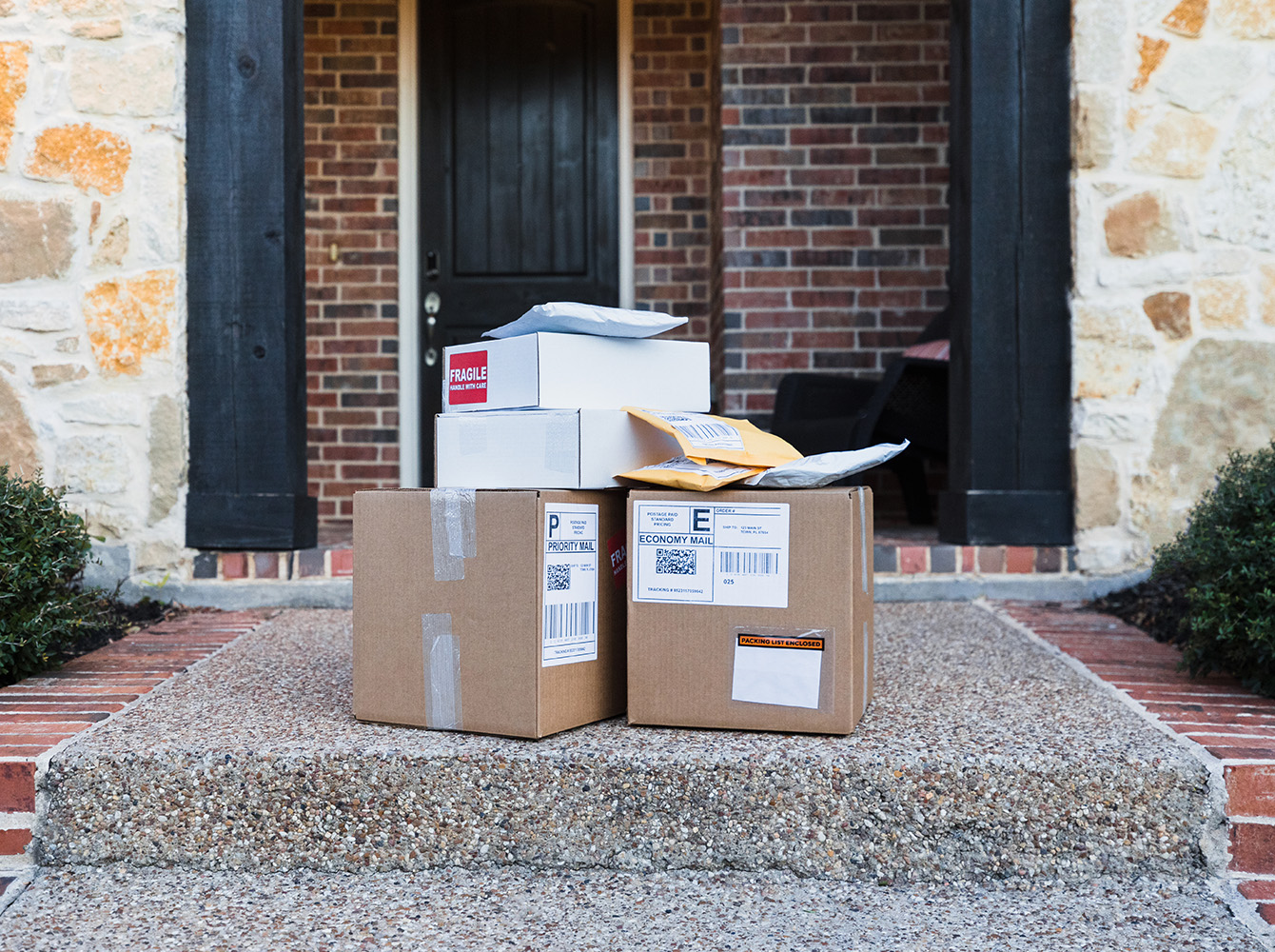 Packages sitting on the front step of a house.