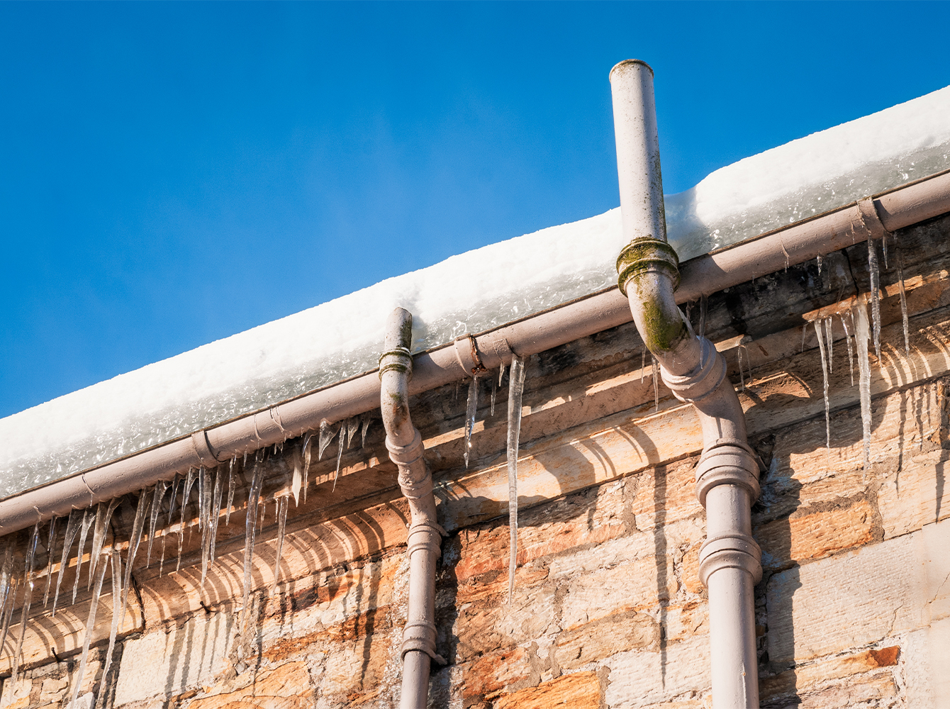Icicles hang from a house's gutter in the winter.
