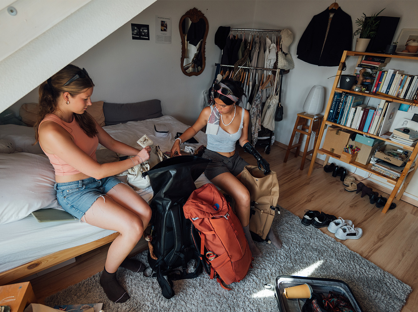 Two women are packing luggage.
