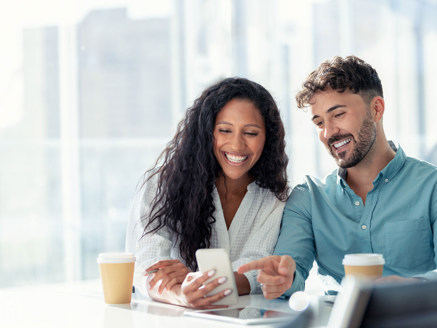 A business man and woman using a tablet in an office