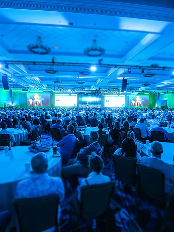 A crowd of seated people looking at the stage during an ISC2 event