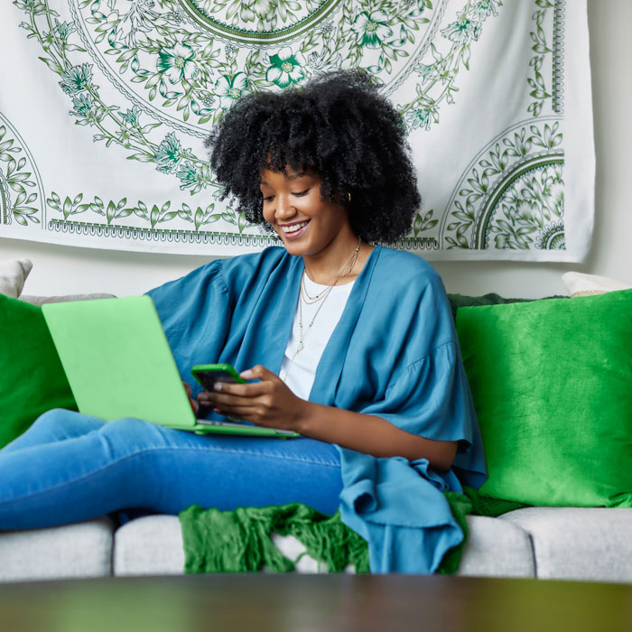 A woman sitting on a couch while using her phone