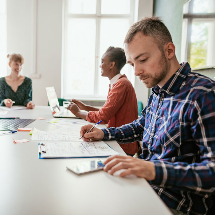 Four people meeting at a table in a modern office