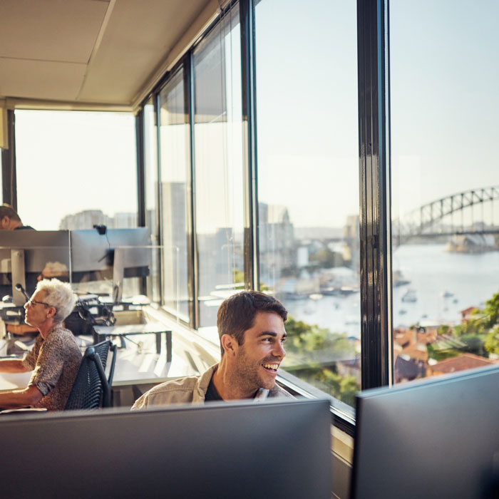 A man sitting at a computer while looking outside a window