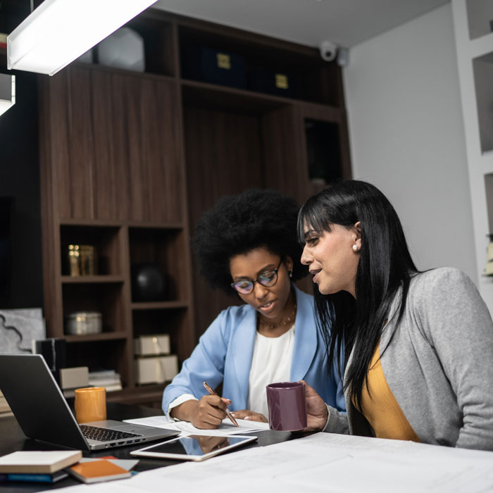 Two women working in an offce at night