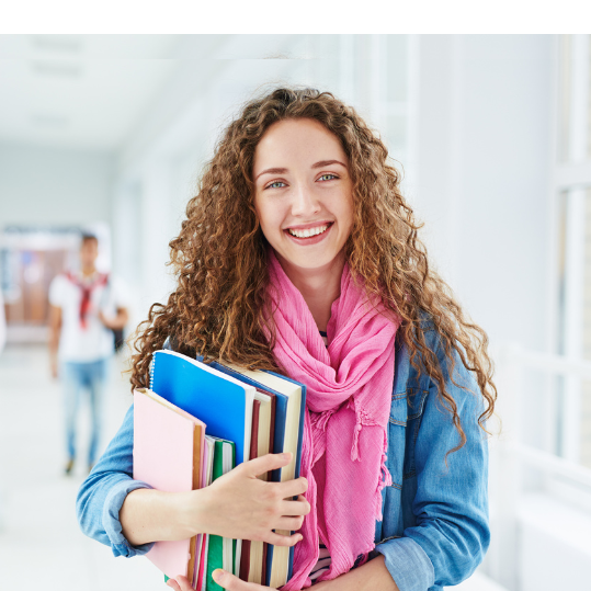 Academic student holding textbooks in a collegiate hallway
