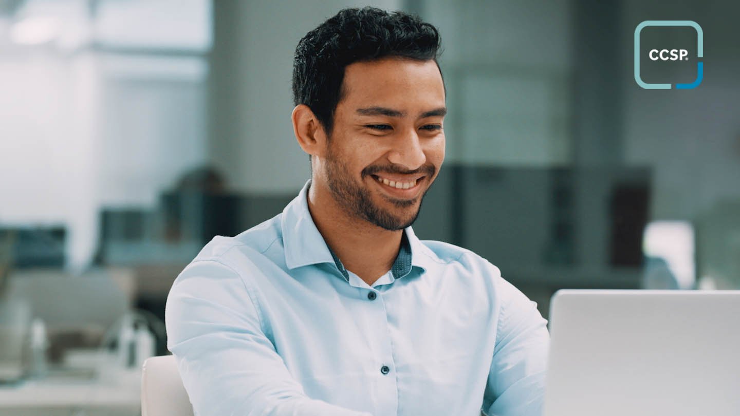 A young man smiling at a computer