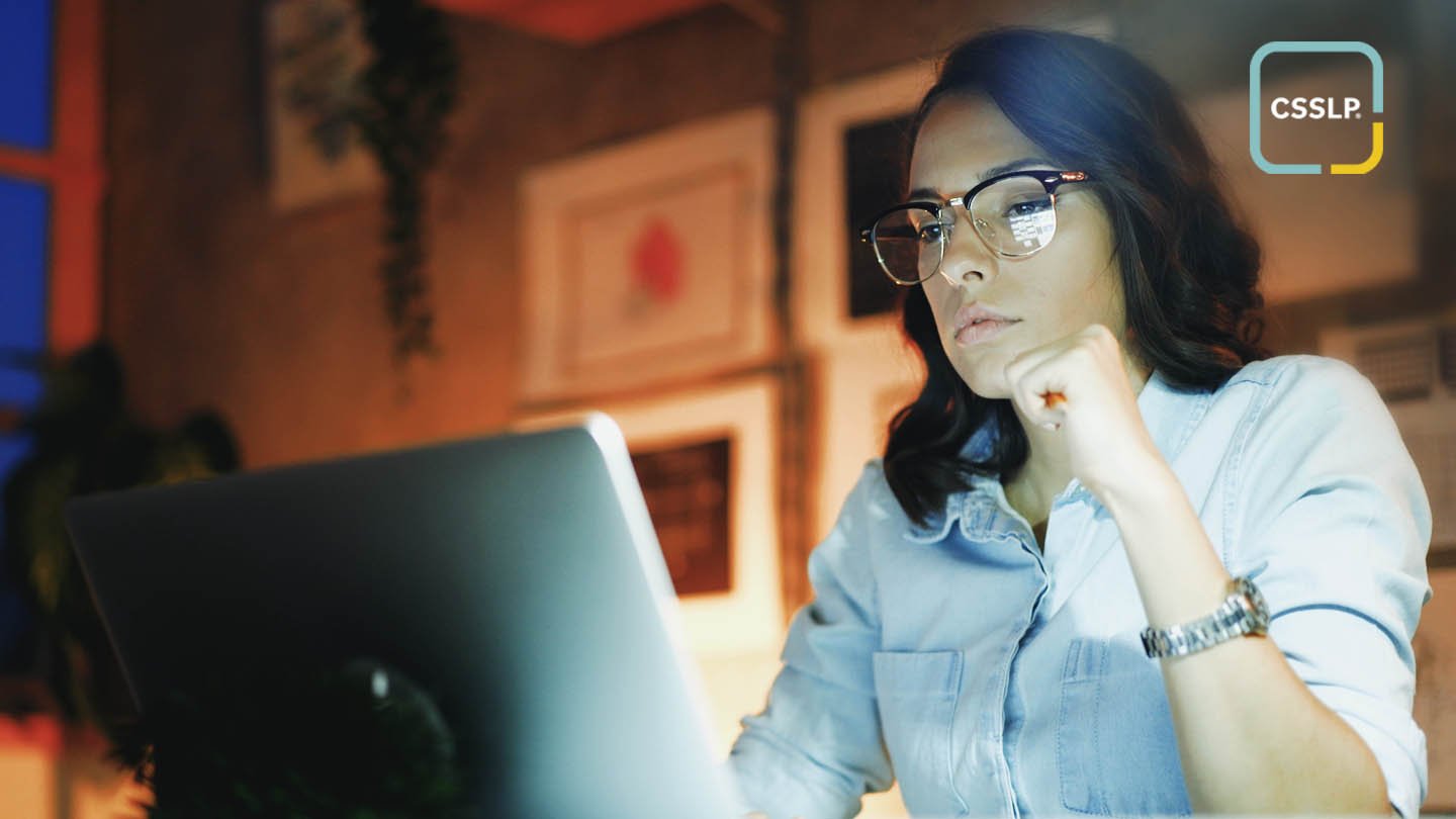 A woman with glasses looking at a computer