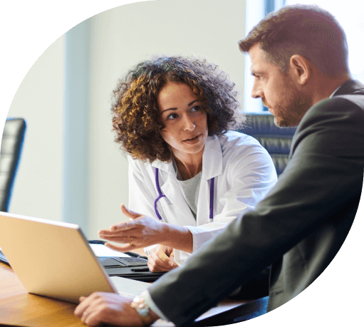 A businessman chats with a female doctor in a hospital boardroom