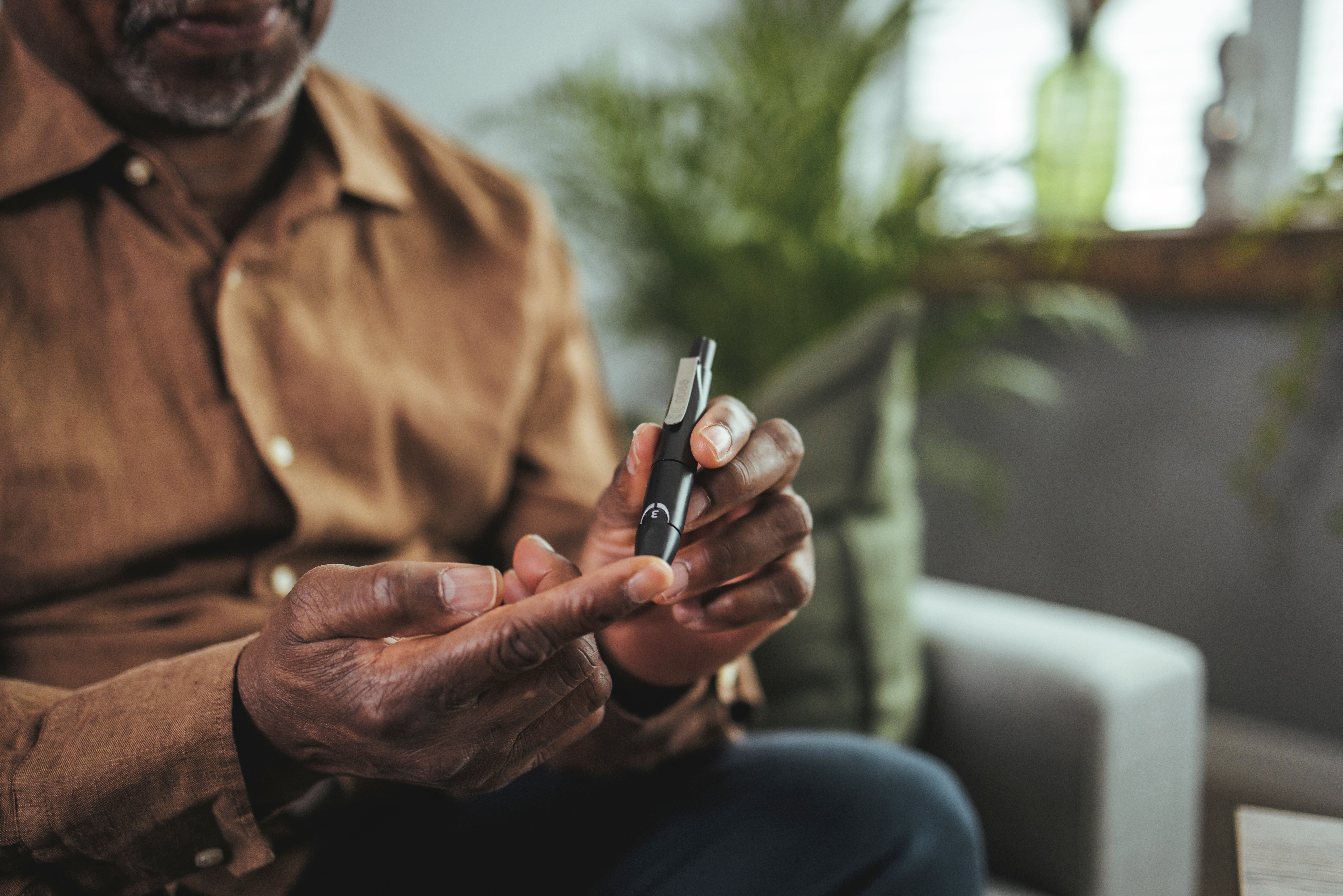 A man using a lancing device on his finger to check his blood sugar