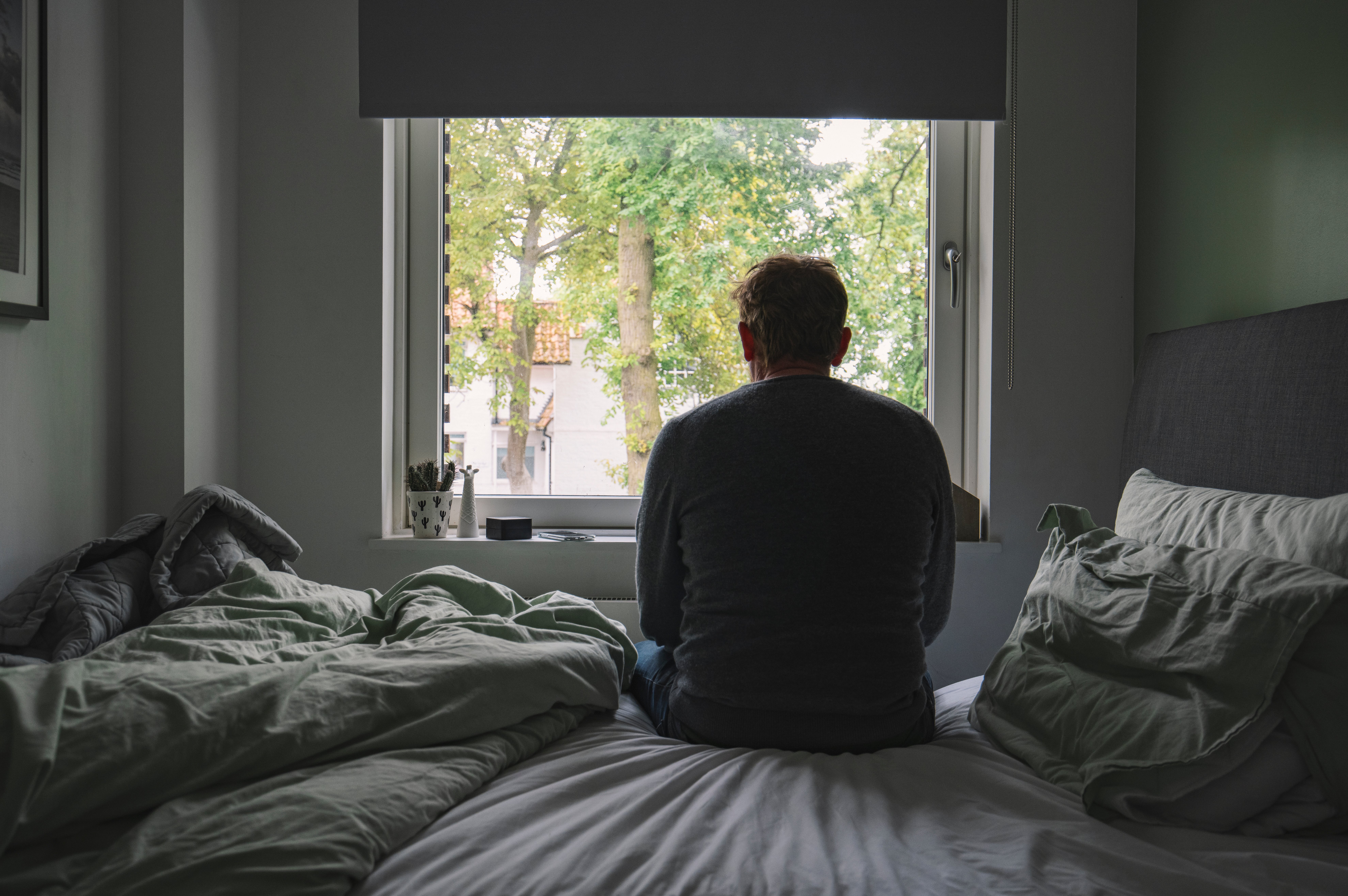 man depressed sitting on the bed