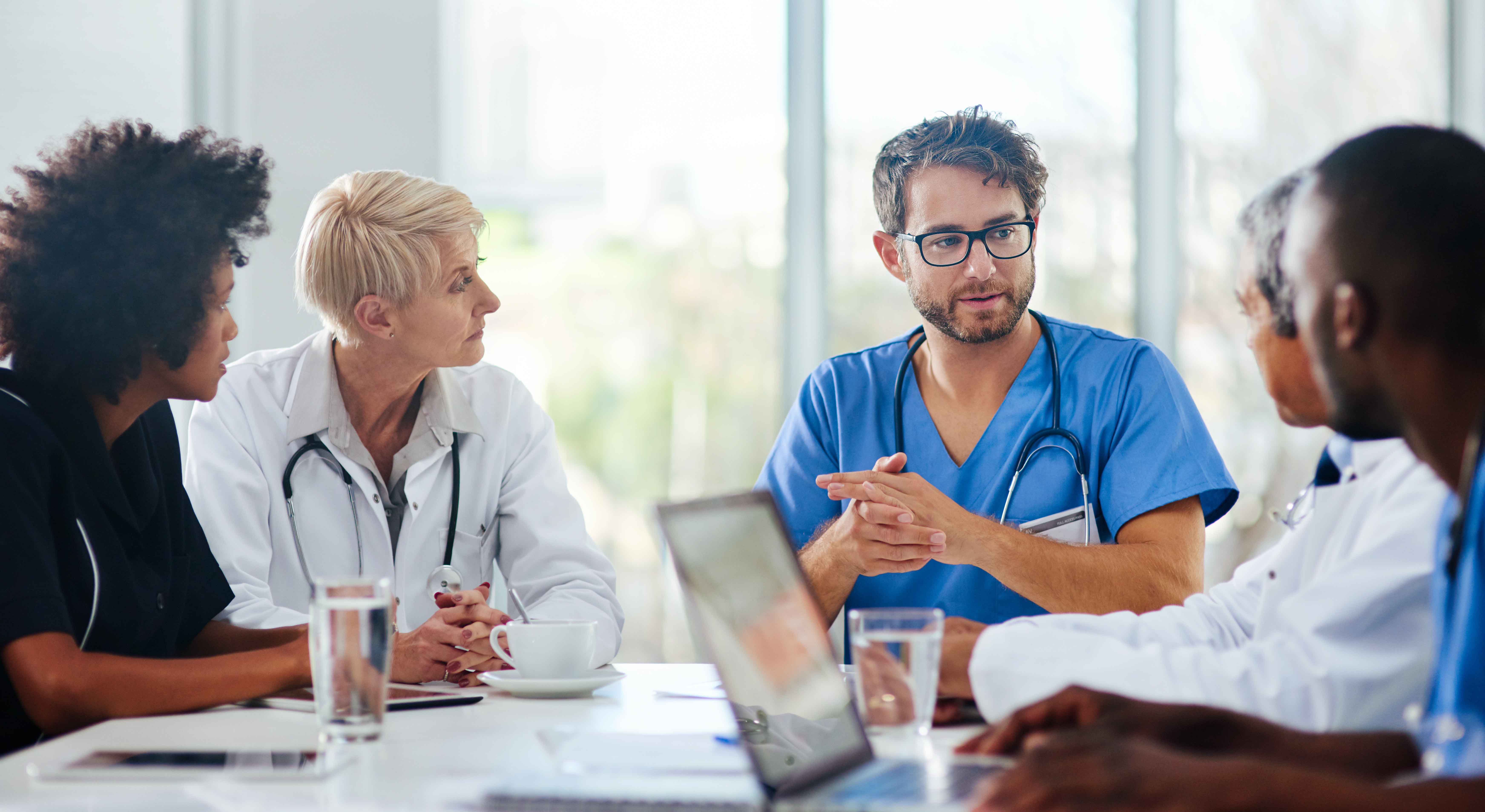 Doctors and nurses talking at a table