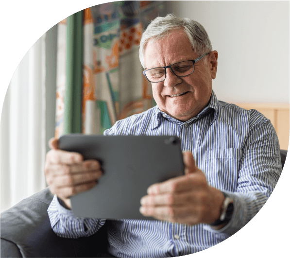 Smiling man reading a tablet