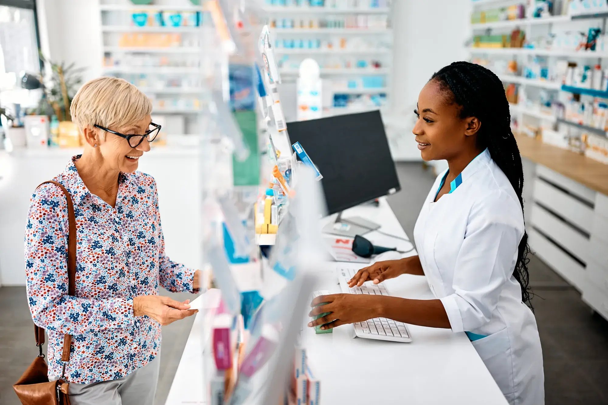 Smiling senior woman buying prescription medicine in a pharmacy.