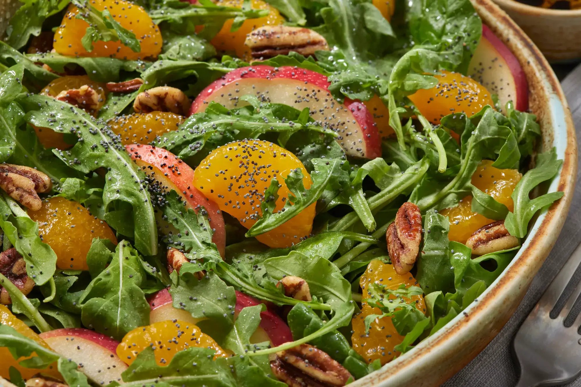Mandarin Orange Salad with arugula, baby spinach, apples, toasted pecans and poppy seeds with an oil and vinegar dressing.