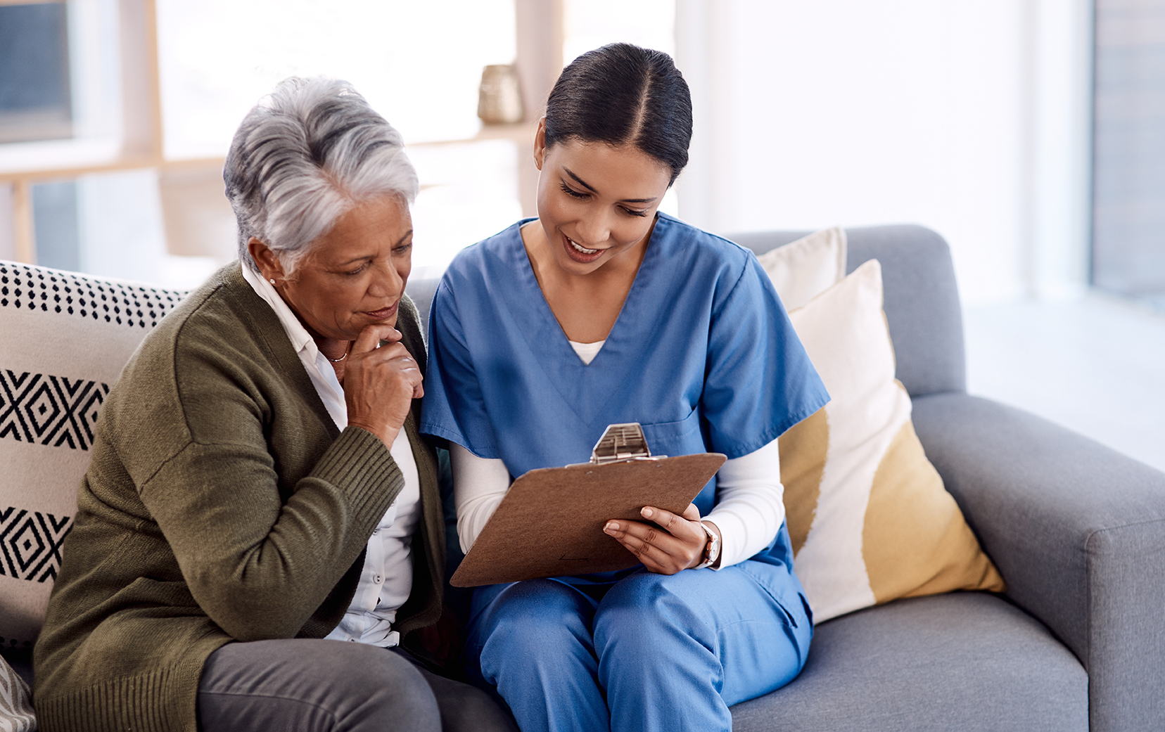 Young nurse explains to elderly patient how best to manage their diagnosis