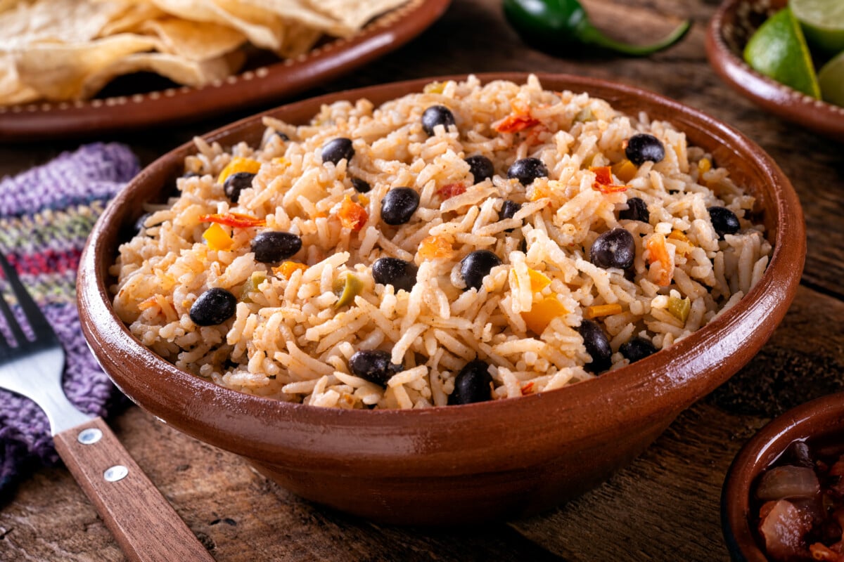 A bowl of delicious black beans and rice on a rustic tabletop