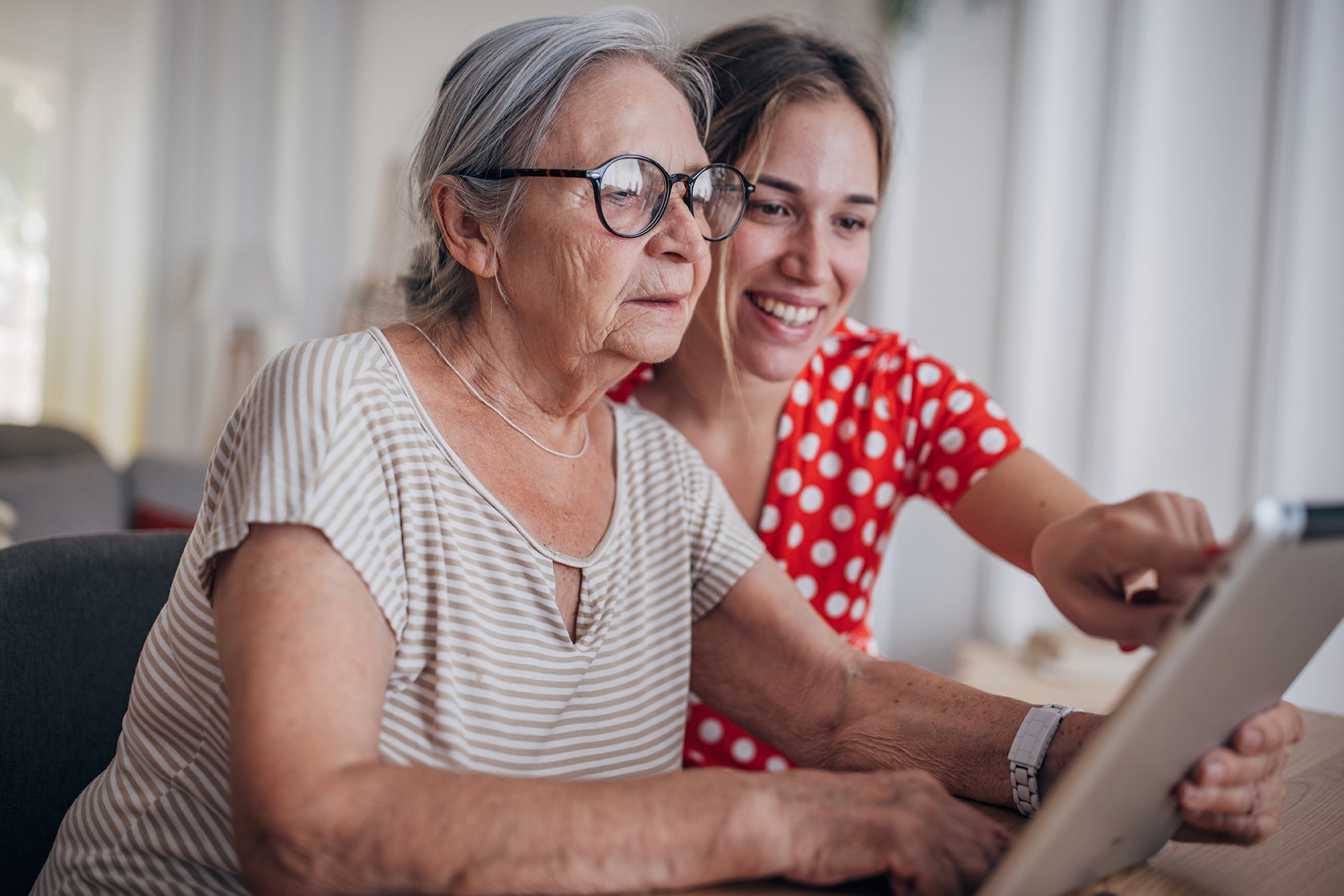 Grandmother and granddaughter using a tablet