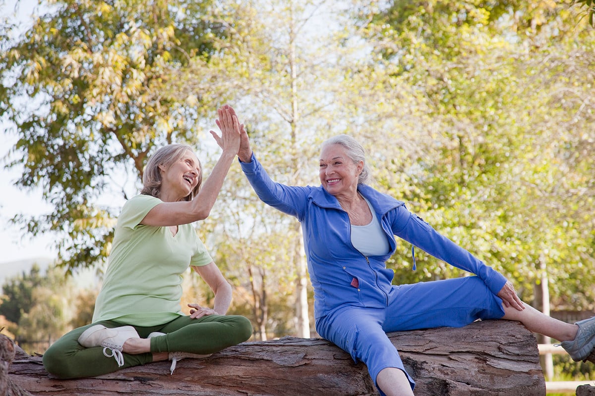 Two women high five after a hike