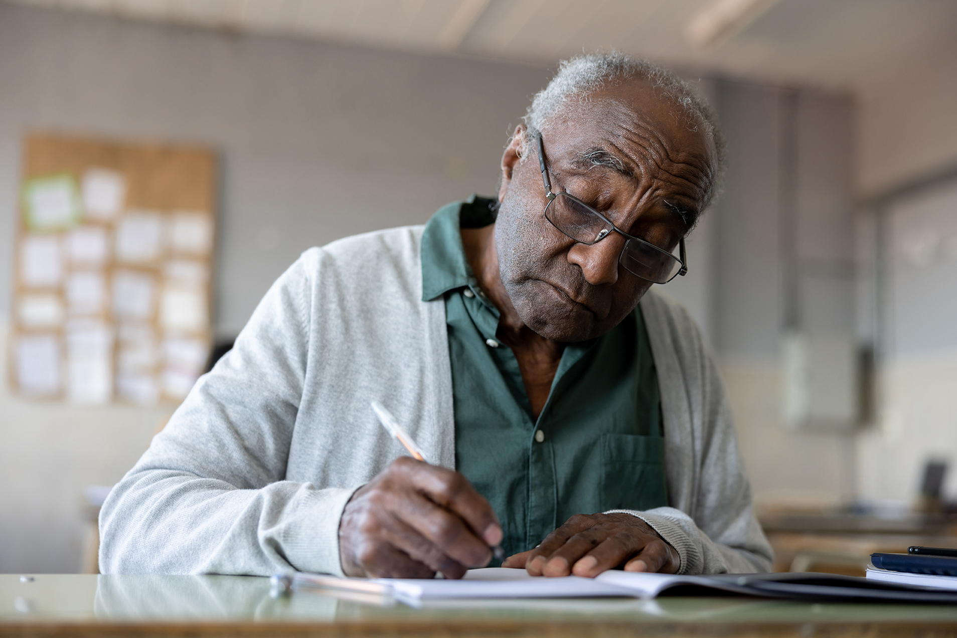 Elderly man writes out a plan in his journal