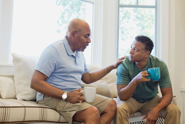 Man talking to adult son over coffee