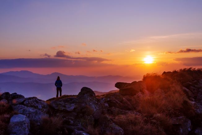 Person on hill alone at sunset