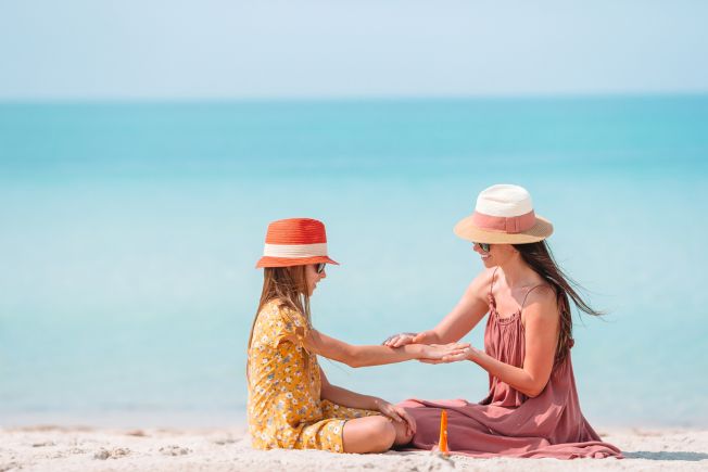 mother and child at beach with sun protection