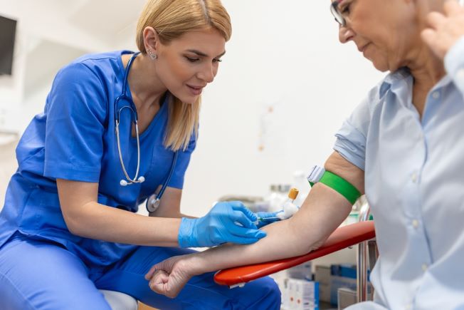 Phlebotomist drawing blood from a patient