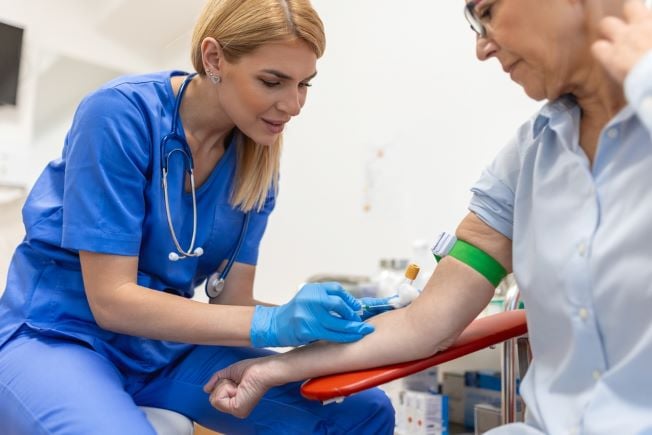 Phlebotomist drawing blood from a patient