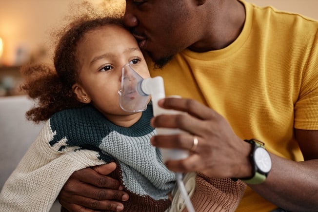 Child with Asthma sitting with dad