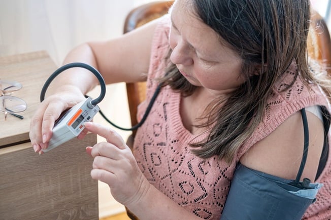 Woman at home taking vital sign reading