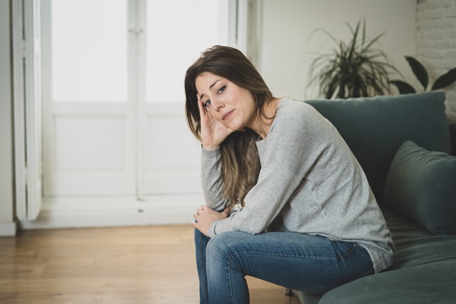Woman sitting down looking very tired