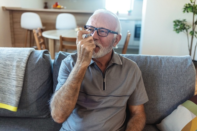 Older man using inhaler