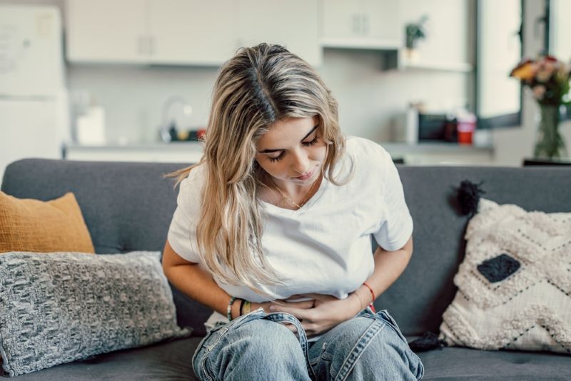 Woman sitting with stomach pain