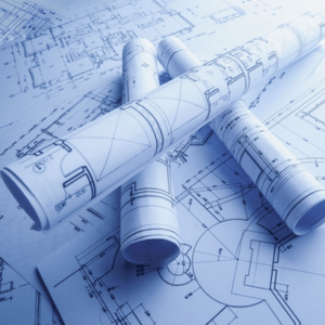 Rolled-up architectural blueprints resting on top of unrolled technical floor plans in a blue tint.
