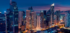 A stunning view of a city skyline filled with lit-up skyscrapers at night.