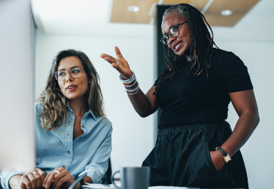 Two woman talking at desk